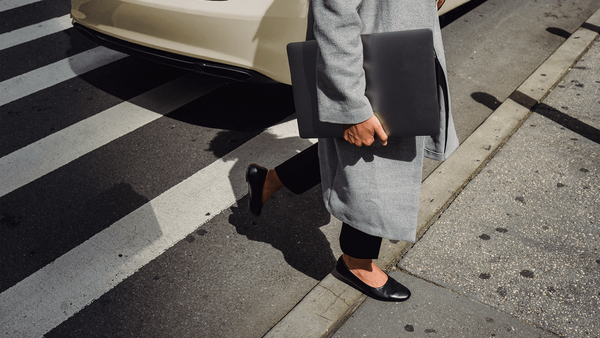 Una mujer camina con su portátil en la mano