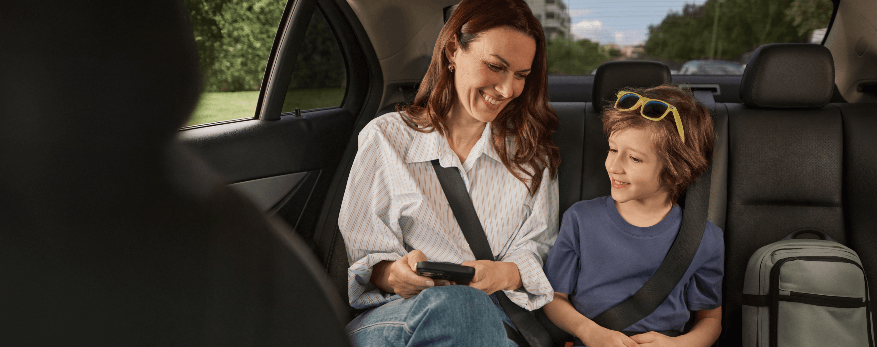 woman and child sitting in the back of a taxi