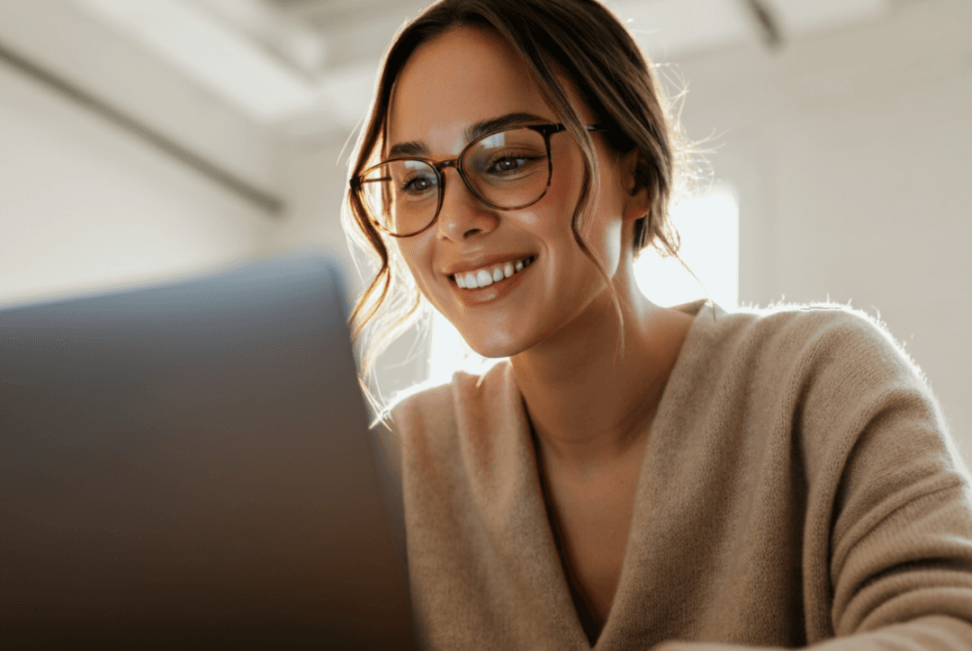 Business travel admin booking taxi on laptop while drinking a cup of coffee